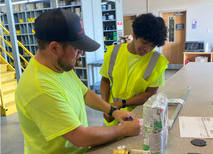 Facilities Management warehouse employees in yellow safety tshirts.